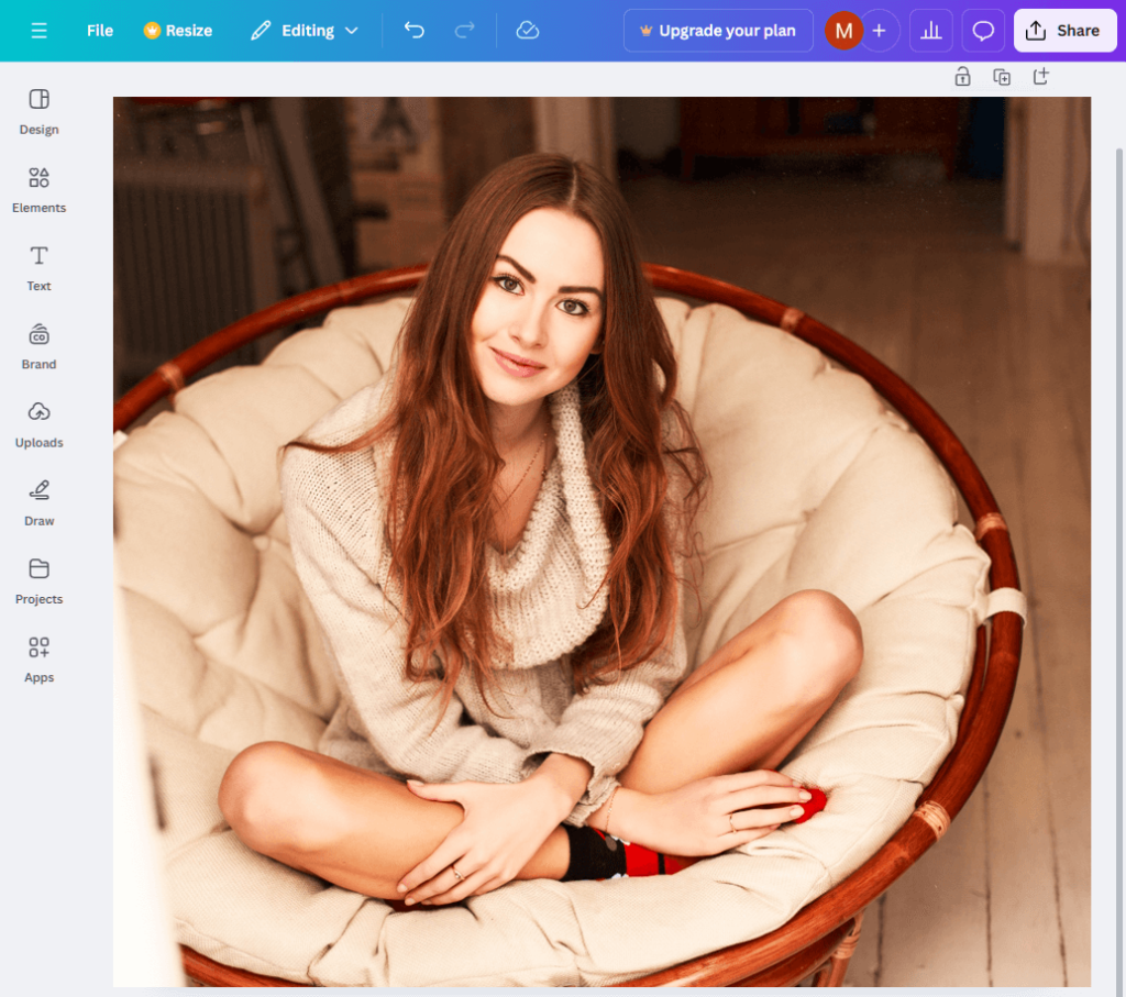 The Canva interface, revealing an image of a young, red-haired, smiling woman sitting in a round armchair