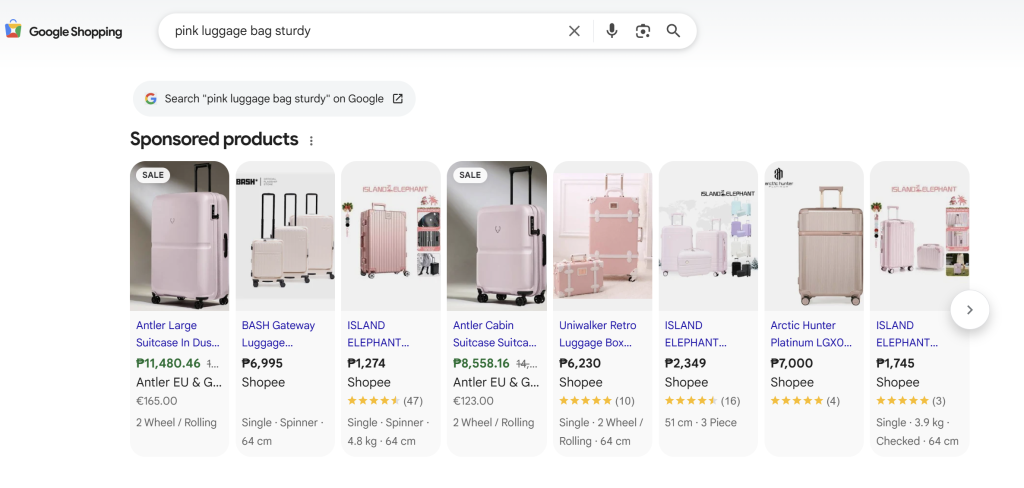 Google Shopping results page showing pink luggage products with high-quality images and pricing details