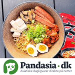 A bowl of ramen topped with tofu, mushrooms, kimchi, soft-boiled eggs, and green onions.