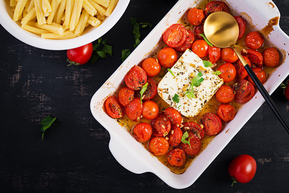 A dish containing tomatoes, basil, and feta cheese, and a bowl containing pasta